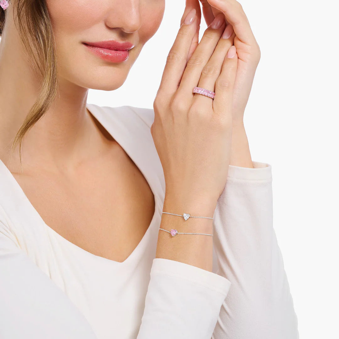 Woman wearing a bracelet and ring with a plain background